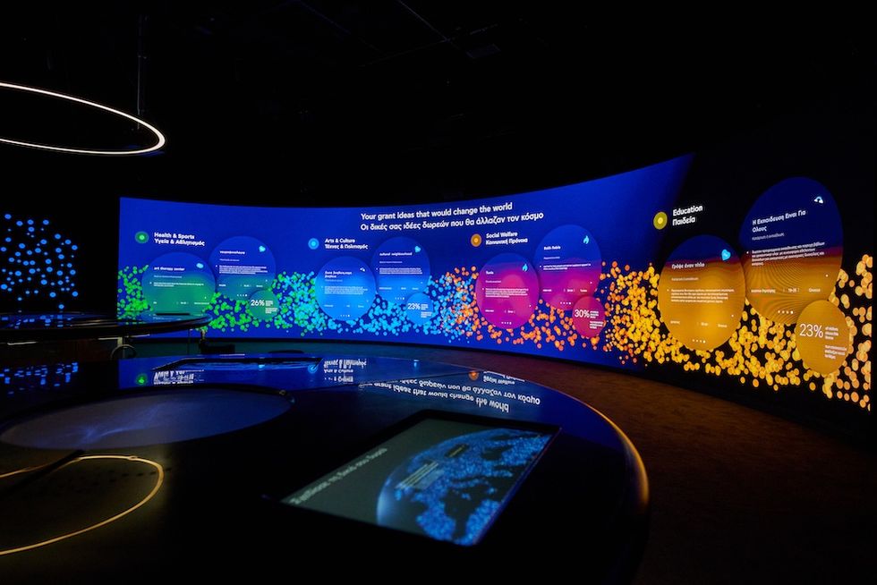 Interactive digital display with colorful circular data graphics in a dark room.
