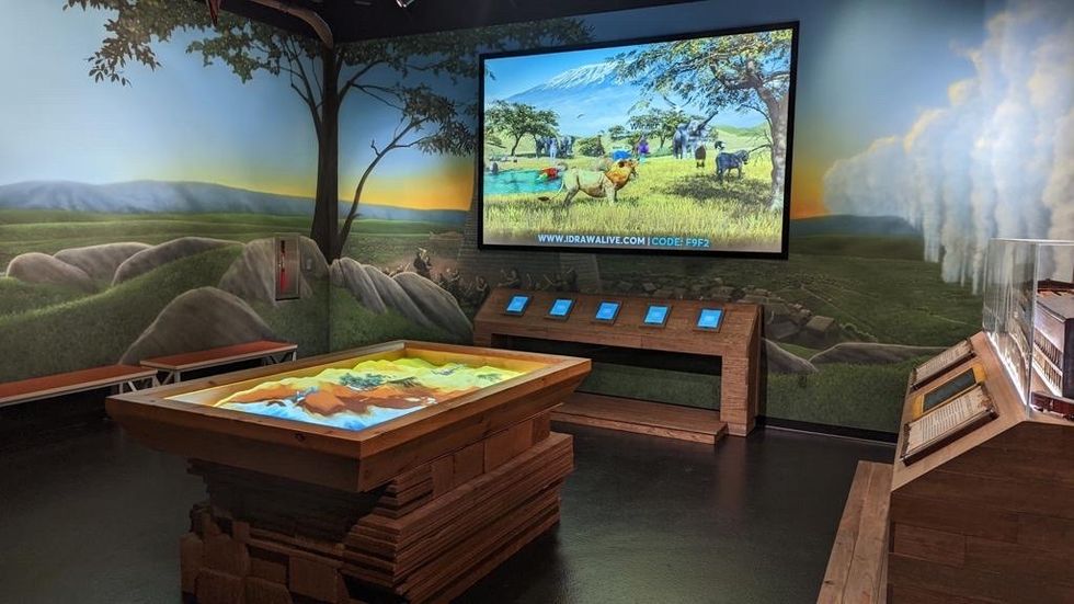 Interactive exhibit room with landscape mural and digital display from \u200bBreeze Creative