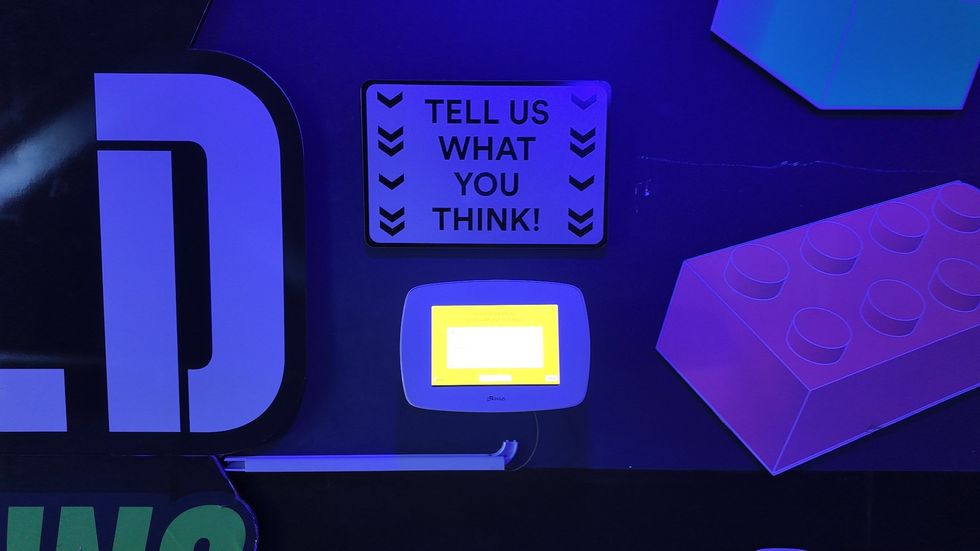 Interactive feedback station with sign: "Tell us what you think!"