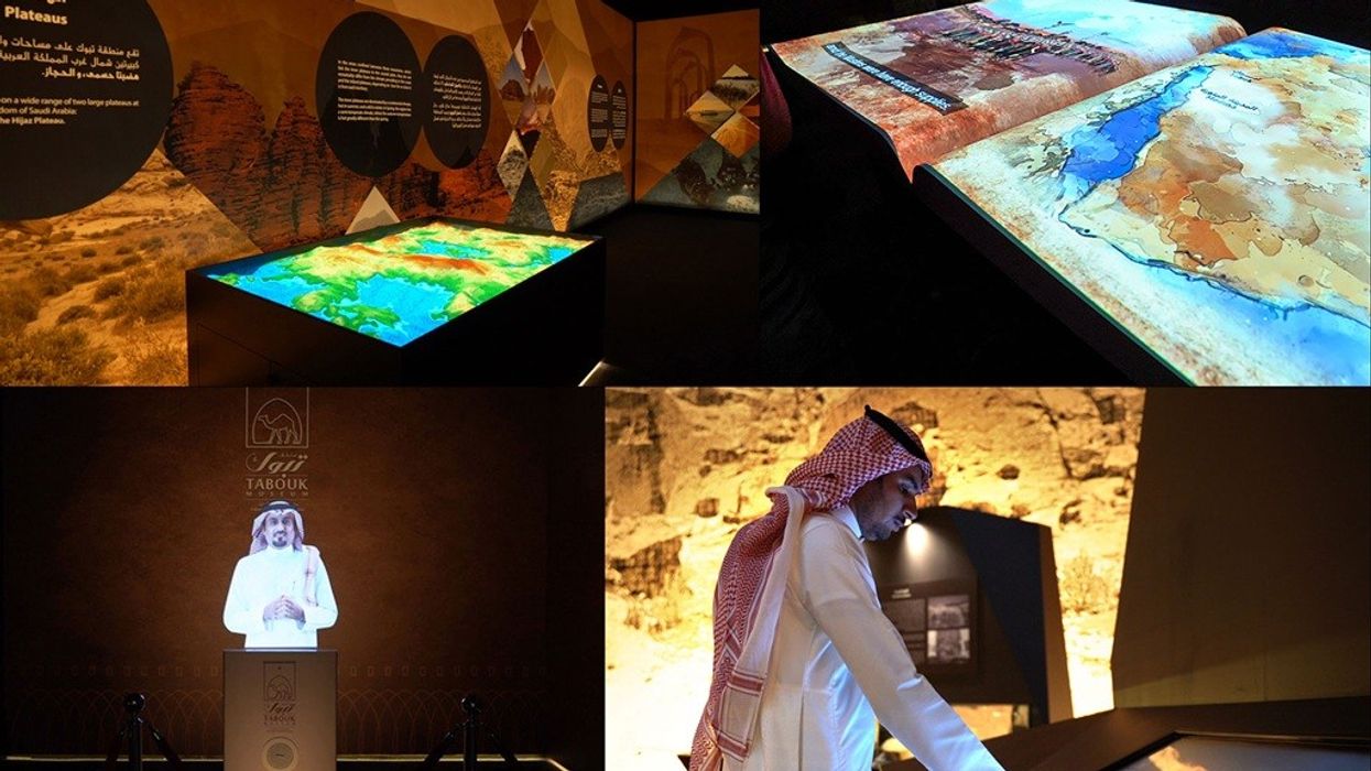 Interactive historical exhibit with maps, displays, and virtual guide in traditional attire.