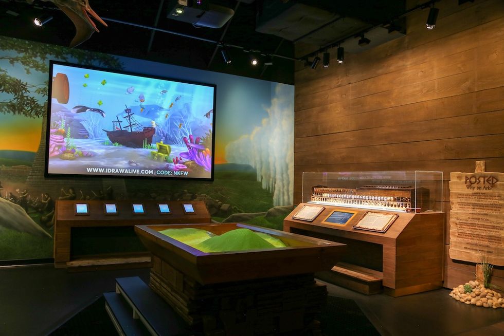 Interactive museum display with a digital screen and wooden exhibits.