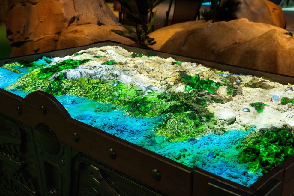 Interactive sand table with colorful topographic map display.