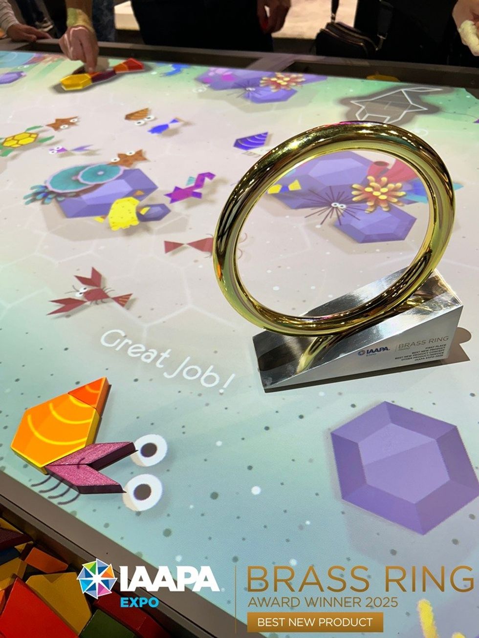 Interactive table display with a Brass Ring award at IAAPA Expo 2025.