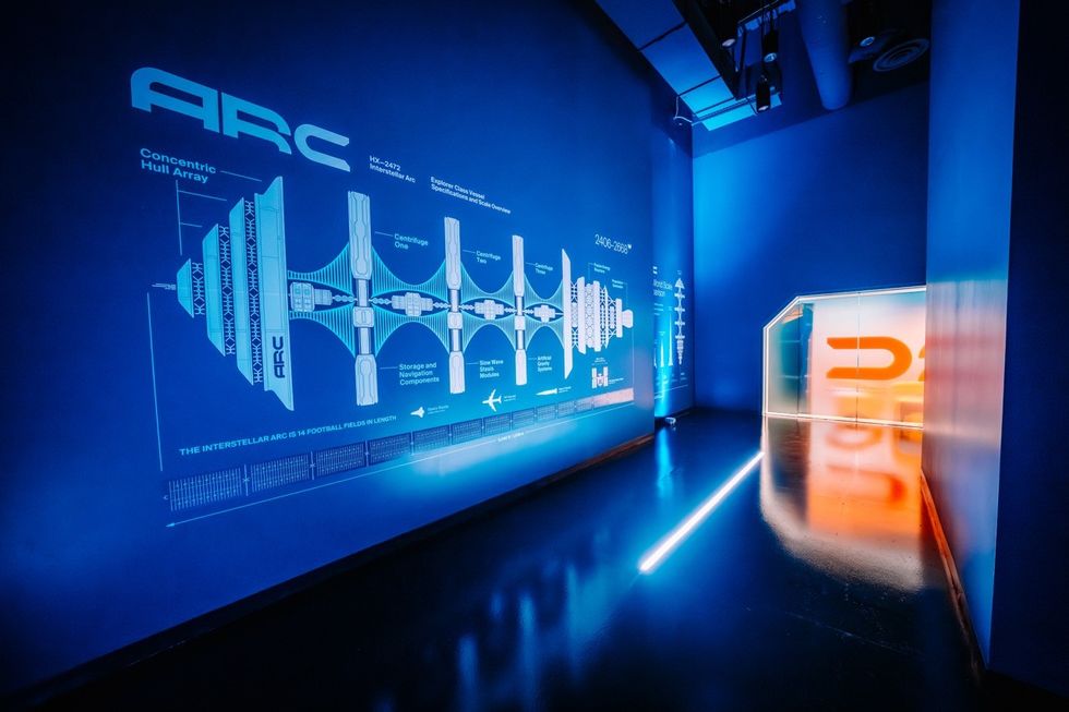 Interstellar Arc Futuristic blue room with technical diagram projected on wall and illuminated doorway.