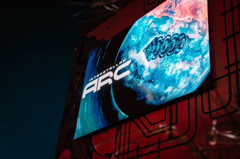 Interstellar Arc Neon arcade sign with a blue planet and "Interstellar ARC" text.