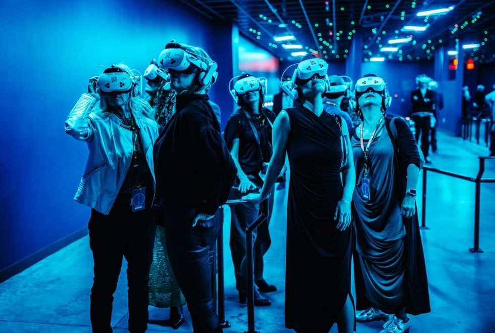 Interstellar Arc People wearing VR headsets in a blue-lit room, looking intently upwards.