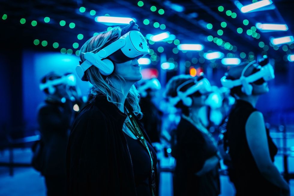 Interstellar Arc People wearing VR headsets in a blue-lit room with dots of green light above.