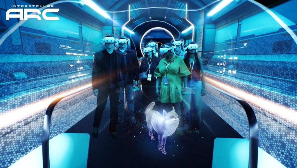 Interstellar Arc People wearing VR headsets in a futuristic hallway with a holographic dog.