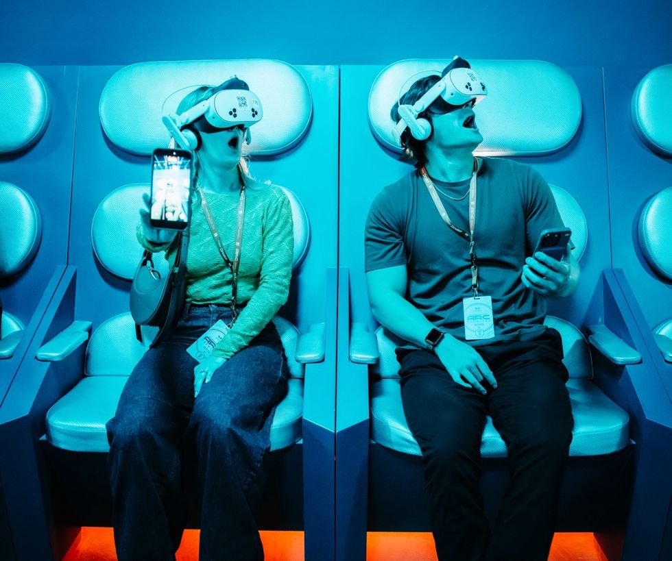 Interstellar Arc Two people in VR headsets experience immersive technology in a blue-lit room.
