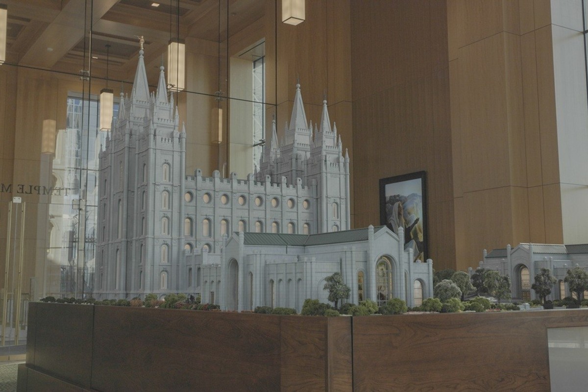 Intricate temple model displayed in a modern glass-walled room.