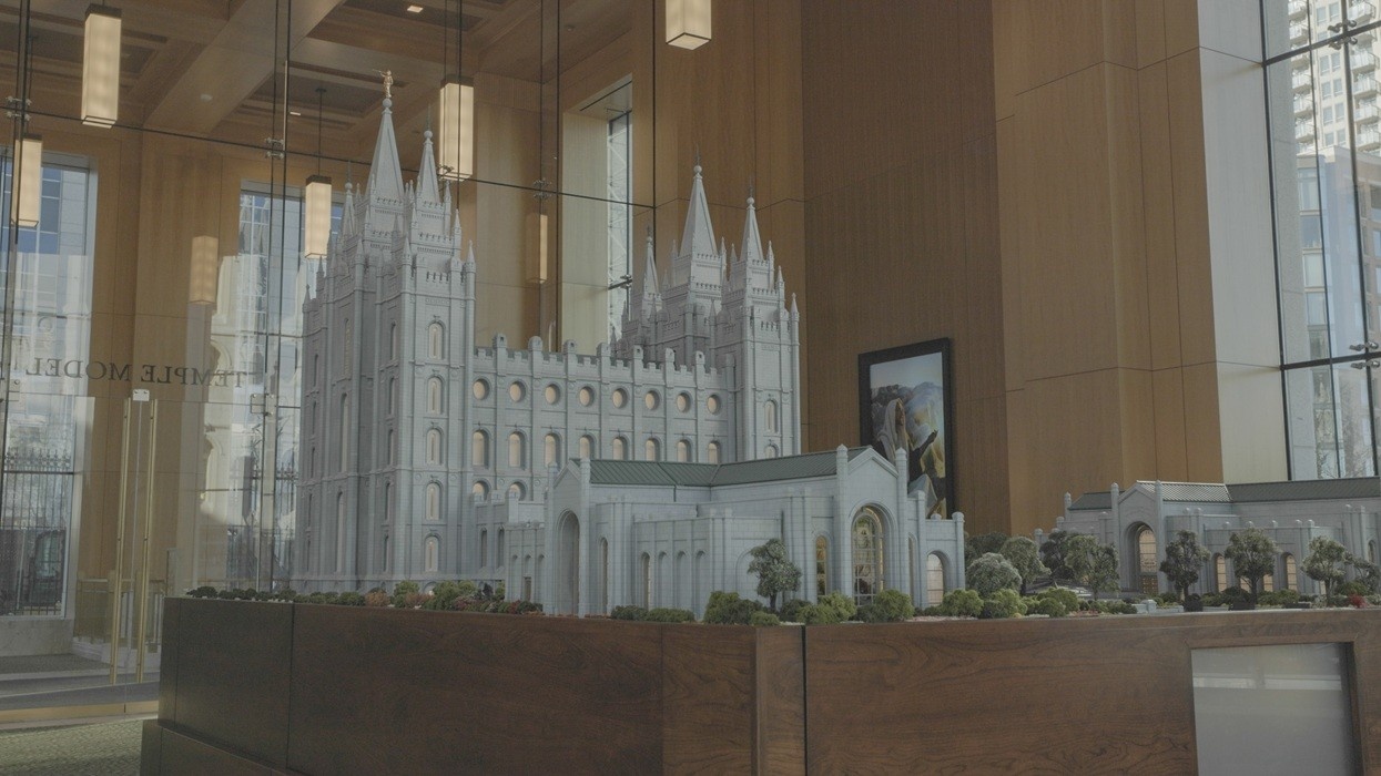 Intricate temple model displayed in a modern glass-walled room.