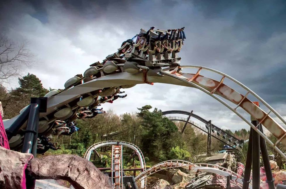 Inverted roller coaster ride, Nemesis, with dramatic cloudy sky.
