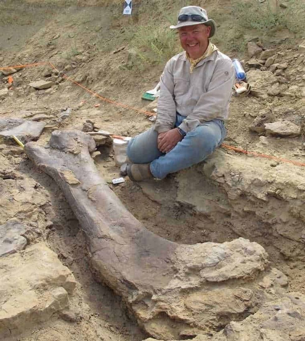Jurassic Mile dig man beside a large dinosaur bone in Wyoming