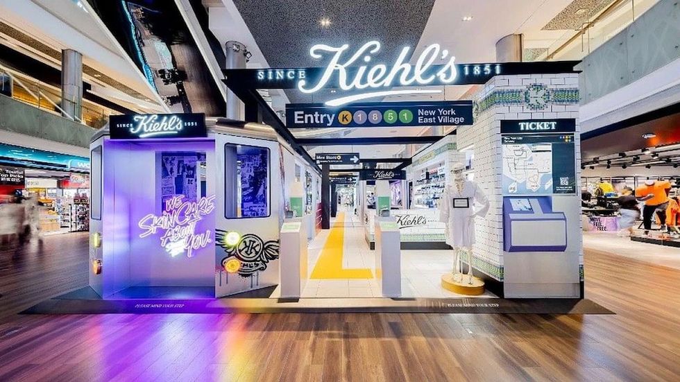 Kiehl's NYC-themed store display with subway train setup and neon signs.