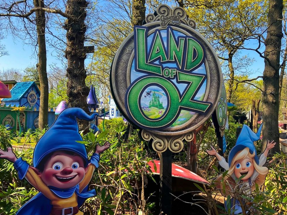 Land of Oz sign with gnome characters in a scenic amusement park setting at Gulliver's World