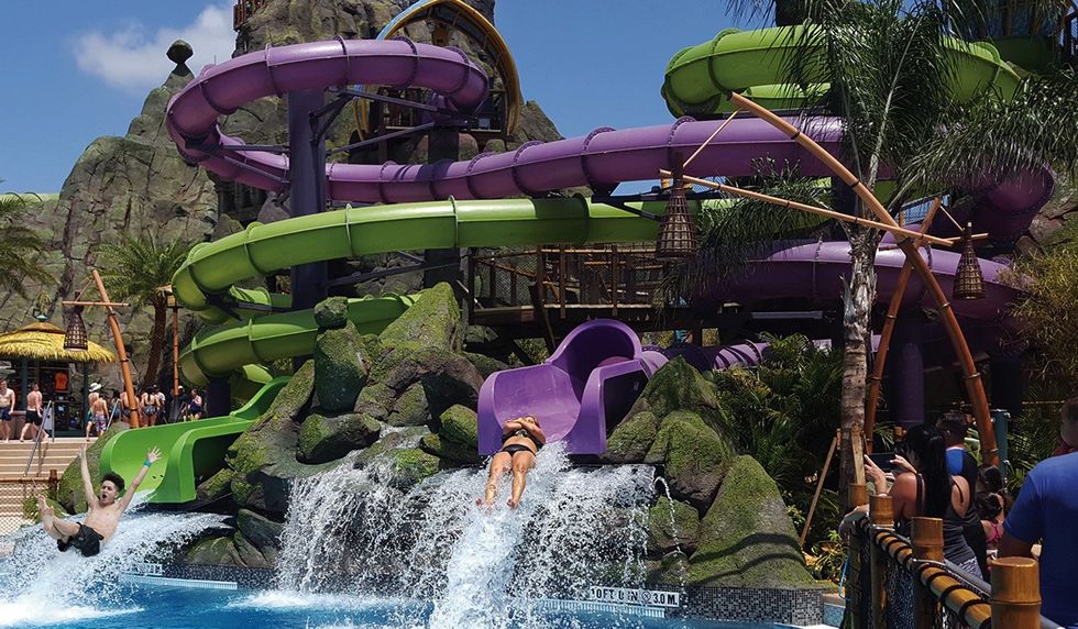 Landscape view of two individuals coming out of a twister before they hit the water. Water park theming