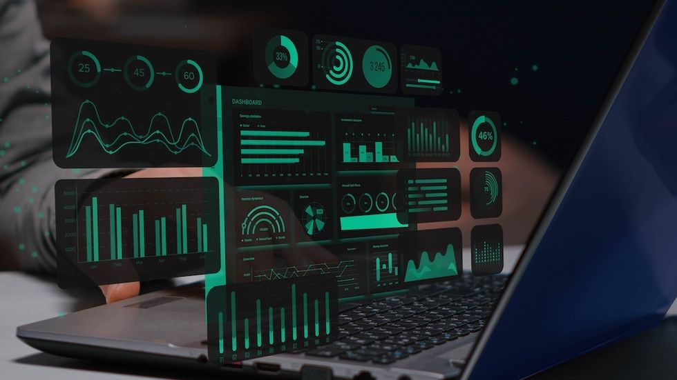 Laptop displaying various data visualizations and graphs in a digital dashboard.