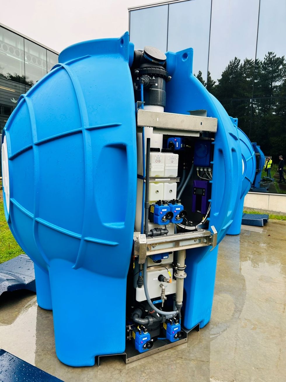 Large blue industrial tank with visible internal components outdoors.