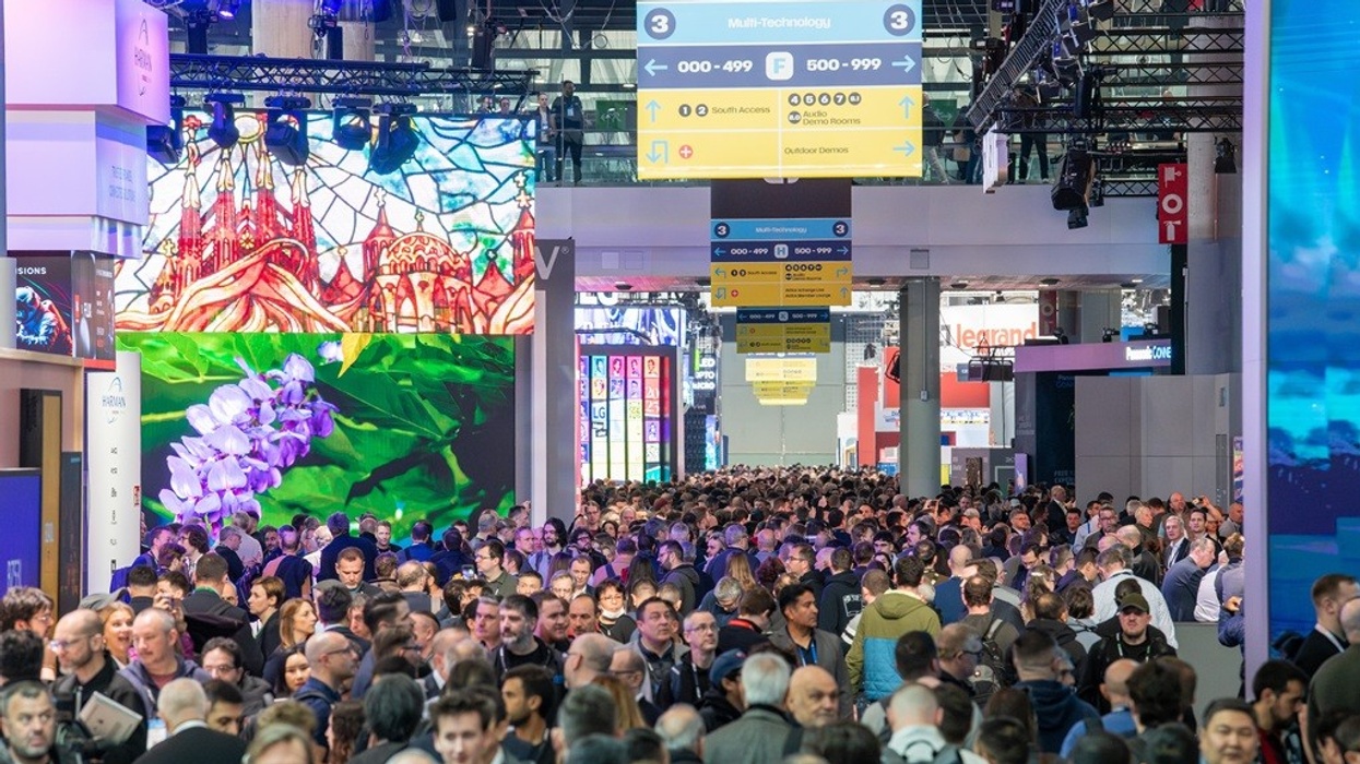 Large crowd at ISE 2025 with vibrant digital displays above.