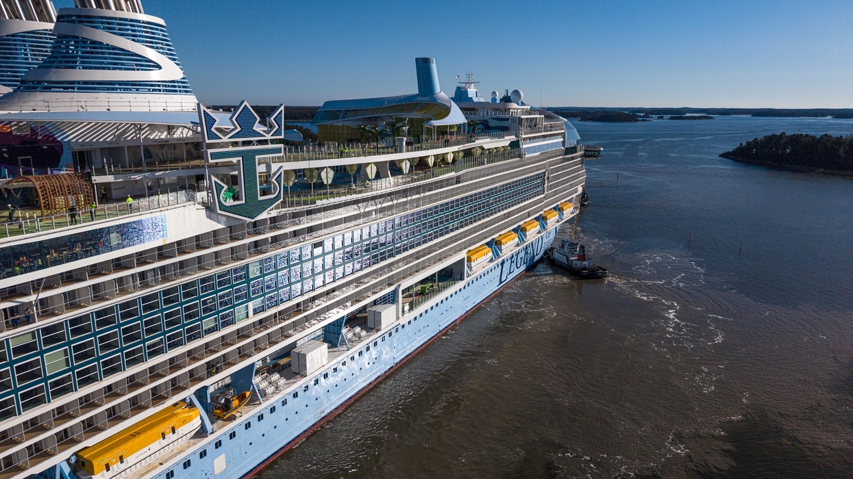 Large cruise ship called Legend of the Seas docked on calm water under a clear blue sky.