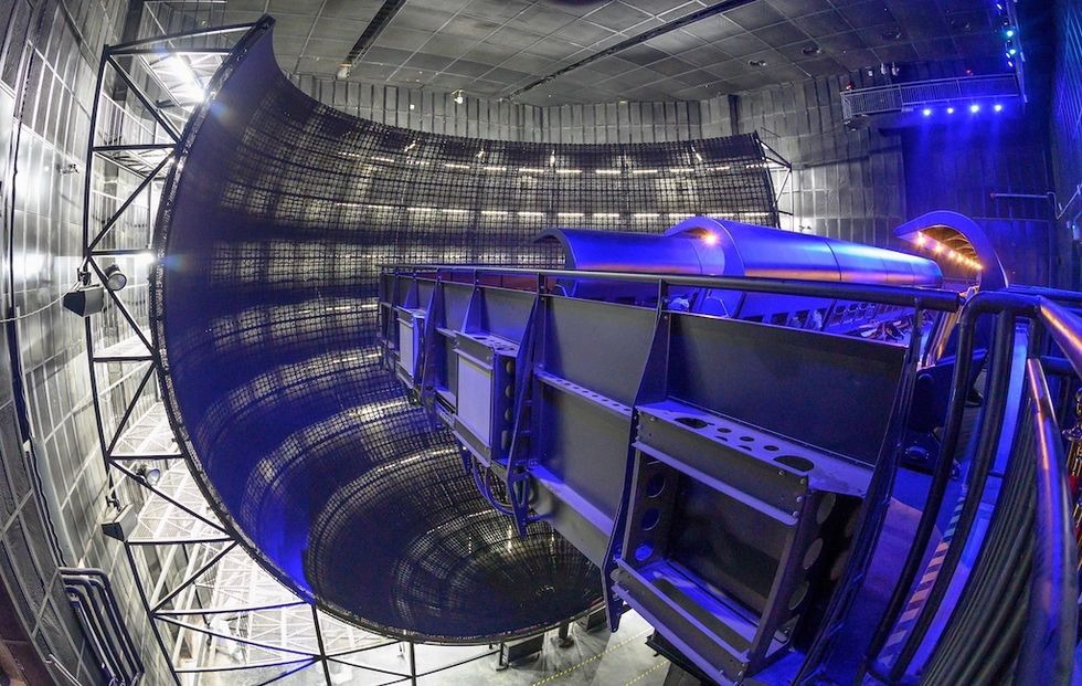 Large curved stage with blue lighting and industrial metal structures, Flying over Jiangsu - Wuxi Sunac Land