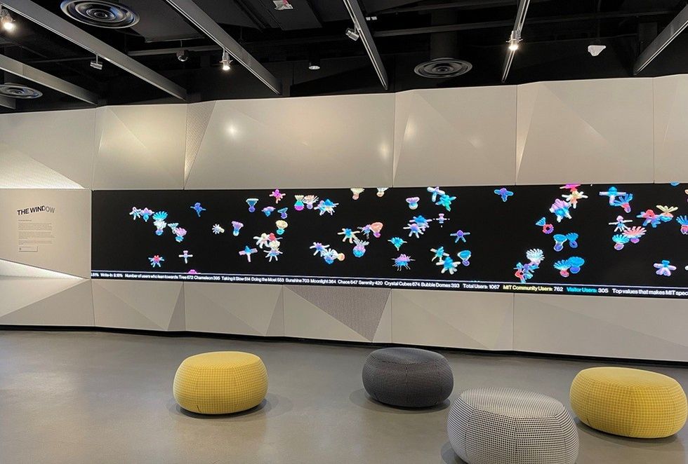 Large digital screen with colorful abstract shapes in modern gallery setting.