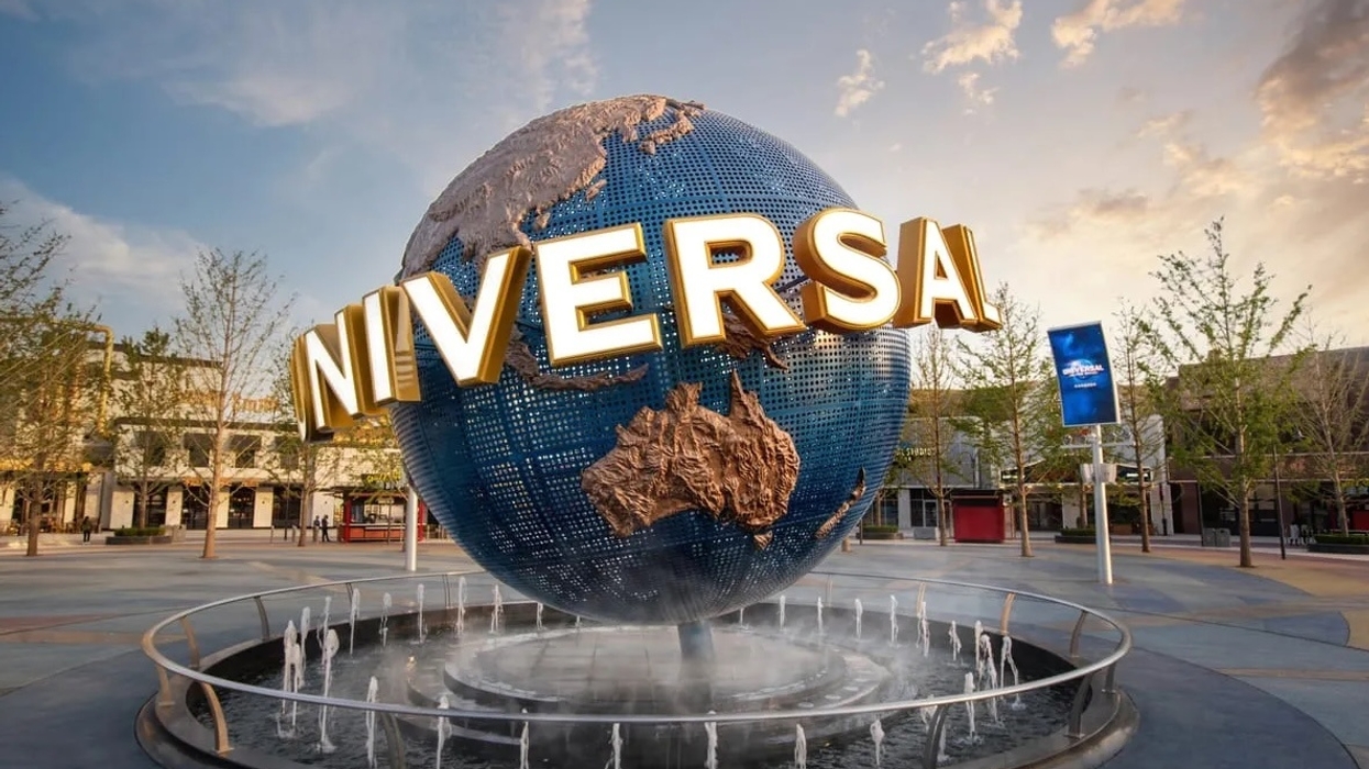Large globe fountain with "UNIVERSAL" letters in a plaza at sunset.