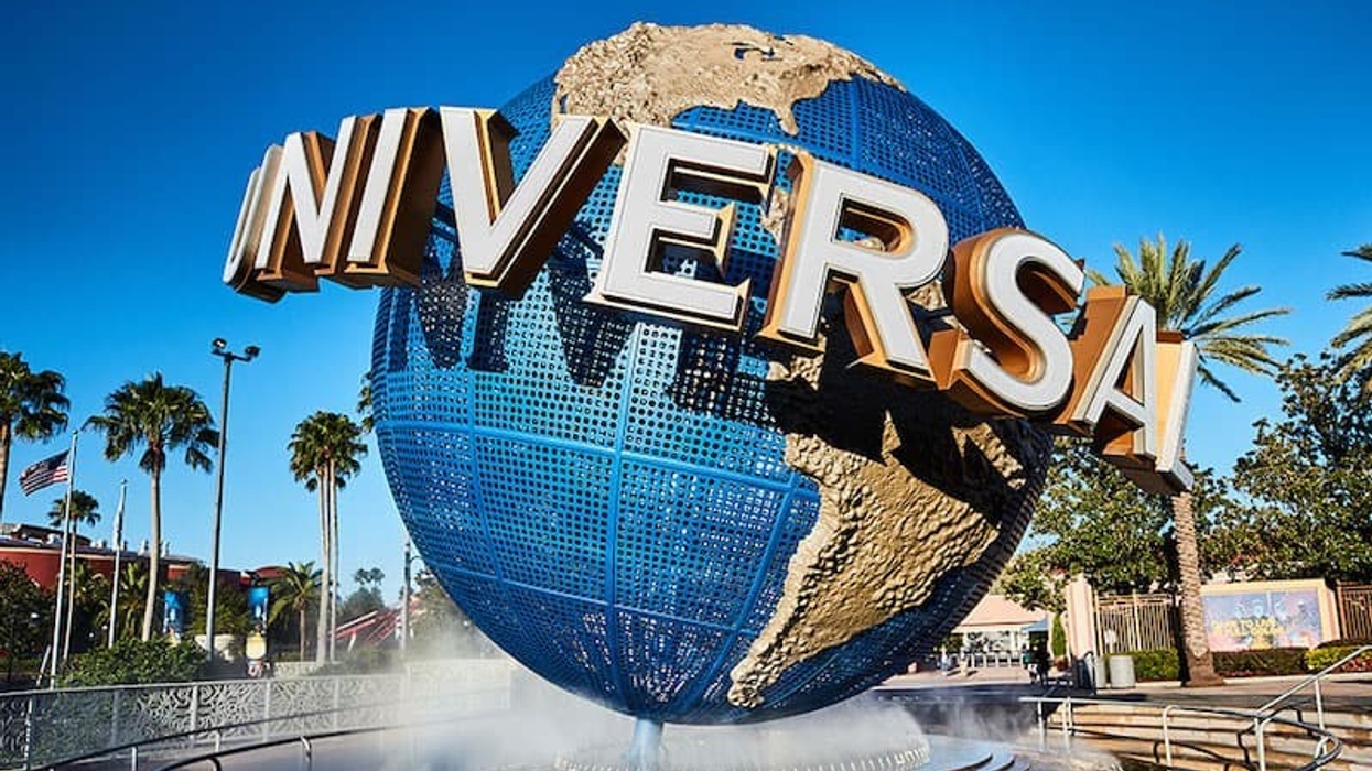 Large globe fountain with "Universal" text, surrounded by palm trees under a clear blue sky.