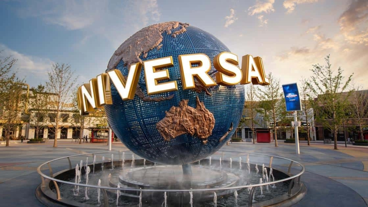 Large globe with "UNIVERSAL" sign and a fountain at an amusement park entrance.