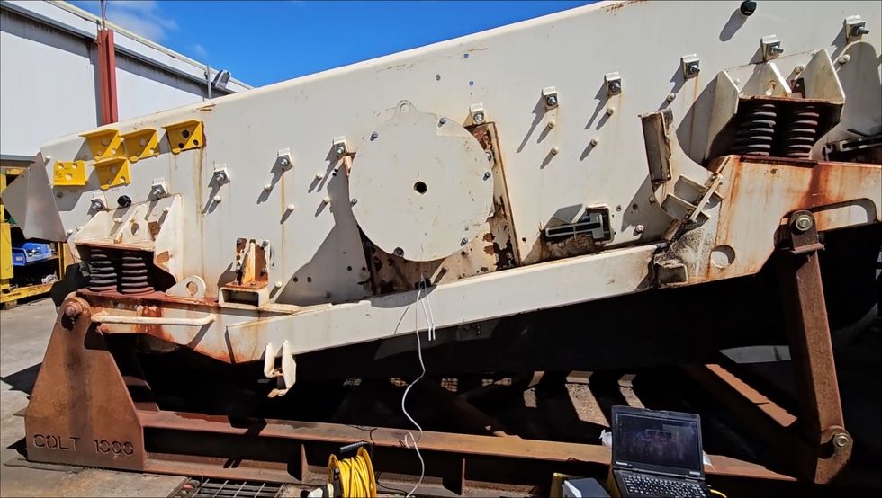 Large industrial Terex machine with rust and a laptop connected in the foreground.