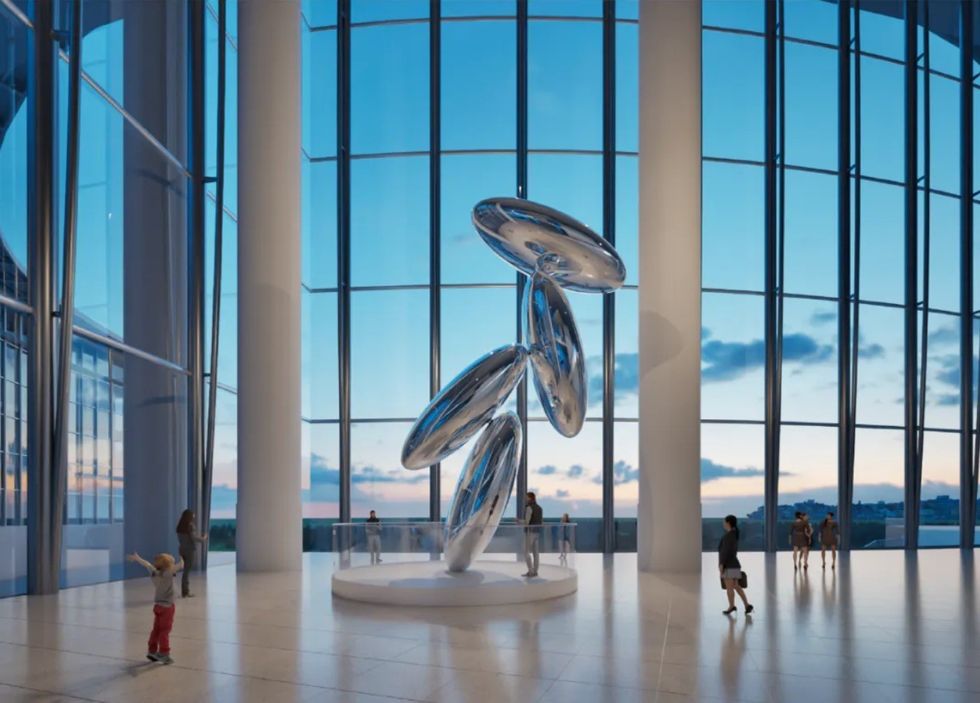 Large metallic sculpture in a glass-walled atrium at sunset, with people observing.