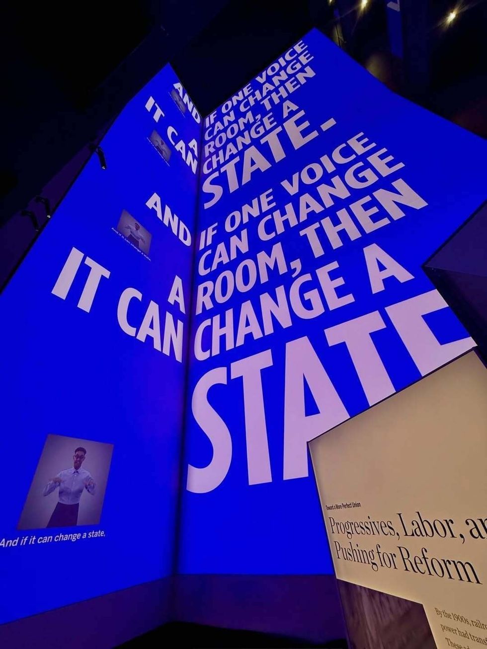 Large projected text: "If one voice can change a room, then it can change a state."