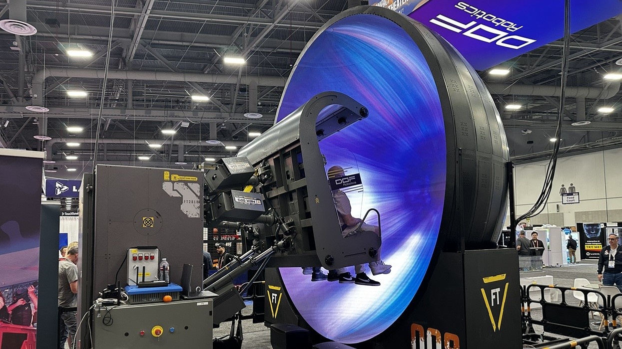 Large robotic simulator with vivid blue lighting at a tech exhibit.