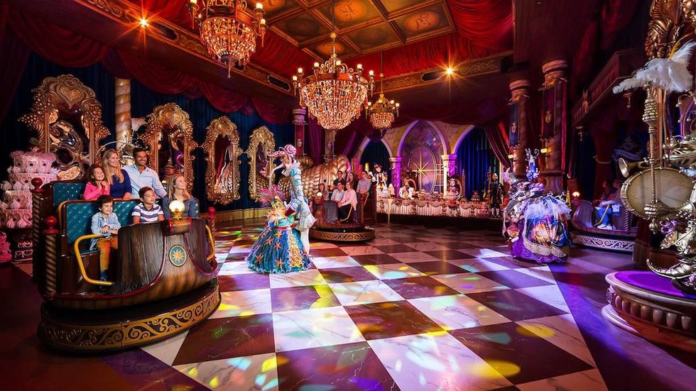Lavish, colorful ballroom scene from Efteling's Symbolica dark ride with people enjoying a vibrant, animatronic show.