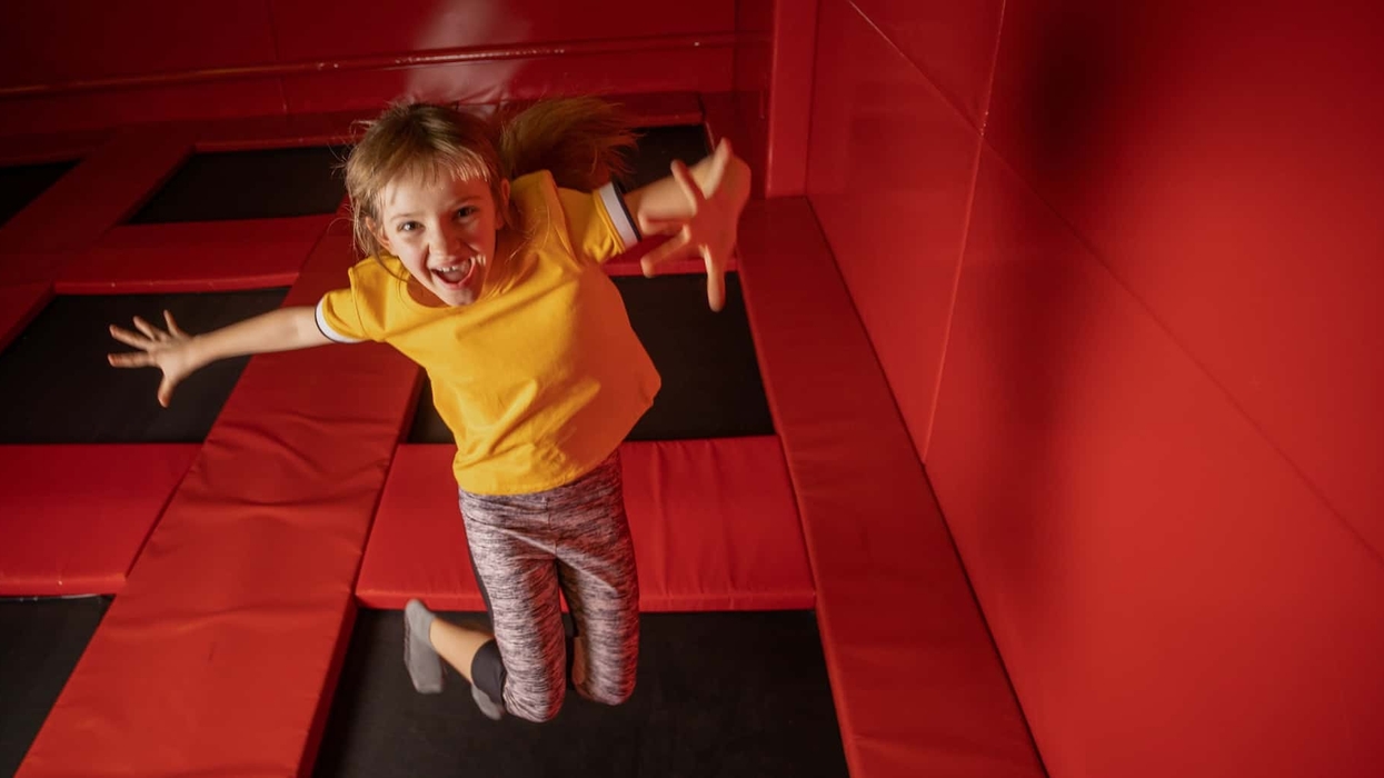 Little girl jumping on trampoline in fly park
