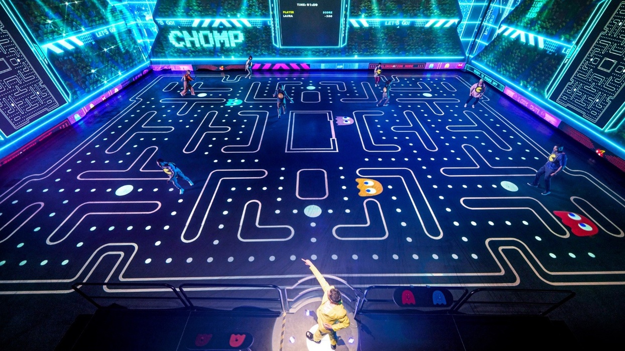 Live-action Pac-Man game with people on a large, illuminated maze, resembling the classic arcade.