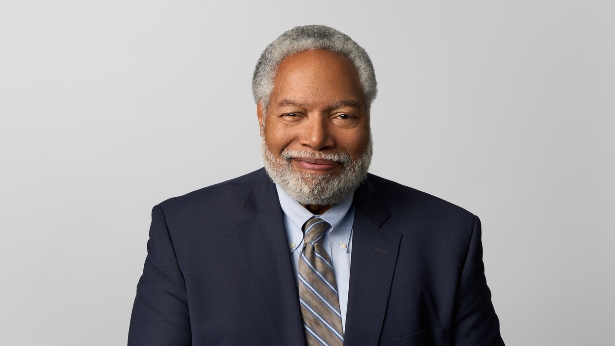 Lonnie Bunch in suit with gray hair and beard against a plain background.
