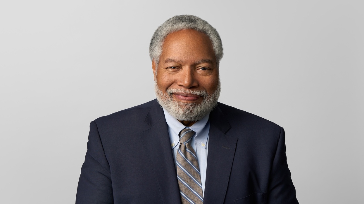 Lonnie Bunch in suit with gray hair and beard against a plain background.