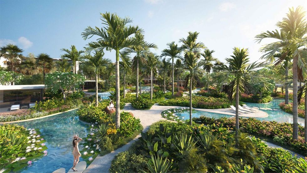 Lush tropical resort called Amaala with winding pools and tall palm trees under a clear blue sky.