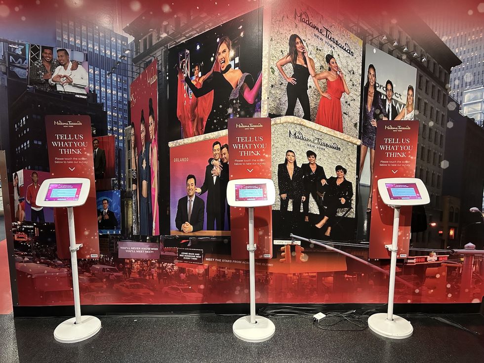 Madame Tussauds wall with interactive survey kiosks in front.