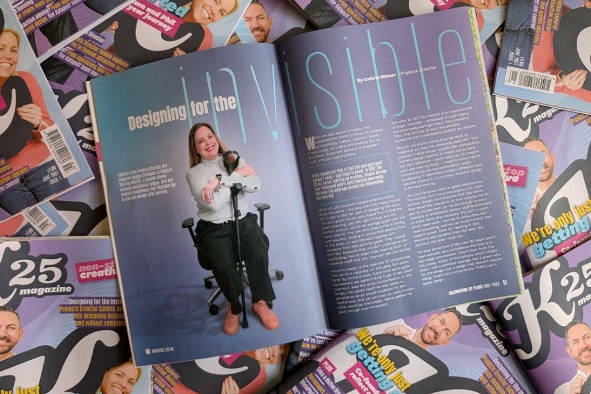 Magazine open to an article titled "Designing for the Invisible" amidst stacked copies.