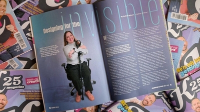 Magazine open to an article titled "Designing for the Invisible" amidst stacked copies.