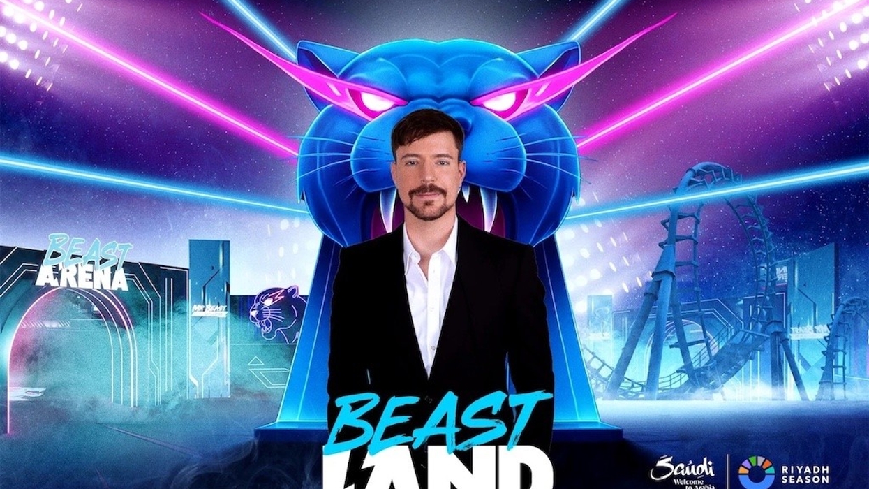 Man in suit stands before neon panther and roller coaster at Beast Land, Riyadh Season event.
