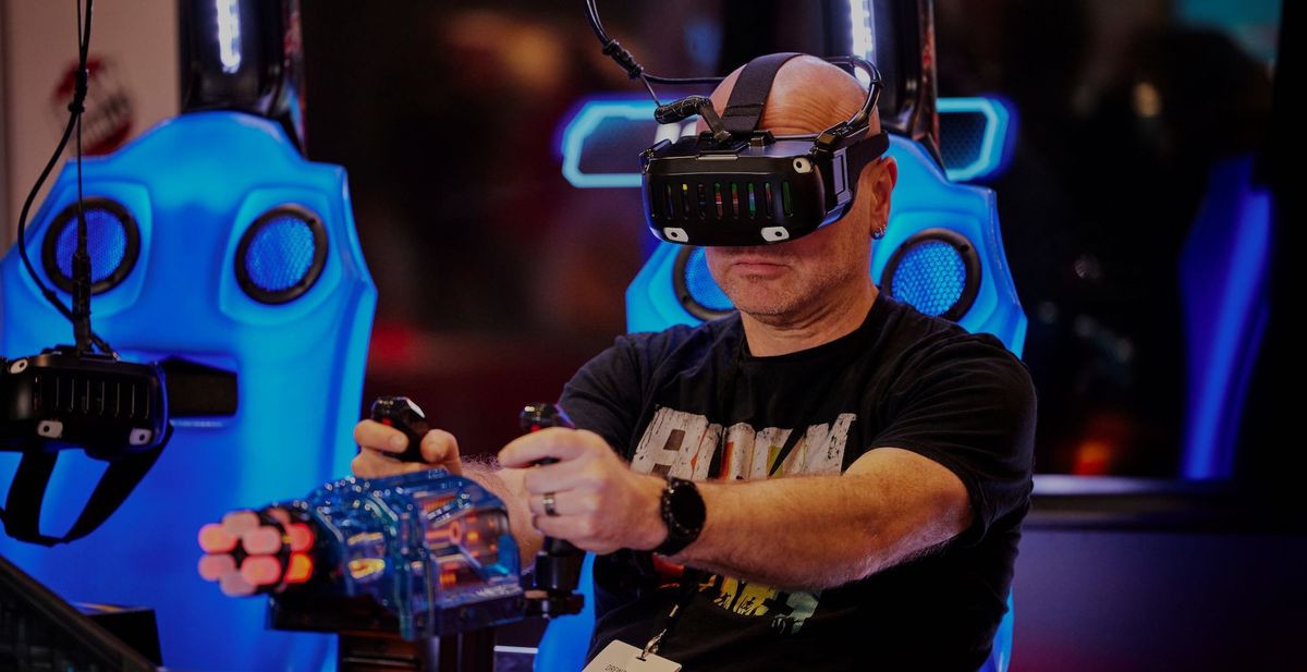 Man plays a VR game wearing a headset, seated at a gaming setup with blue lights.