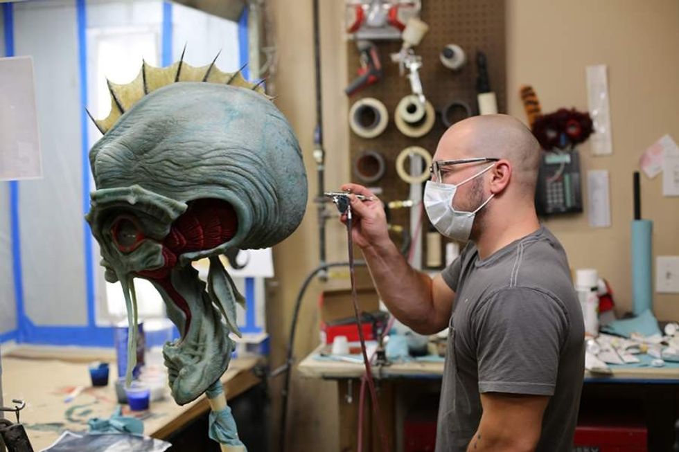 man sprays paint on alien head at animax designs