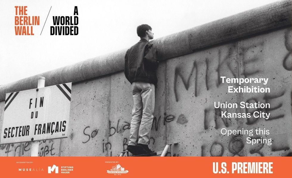 Man standing on Berlin Wall; exhibition at Union Station, Kansas City.
