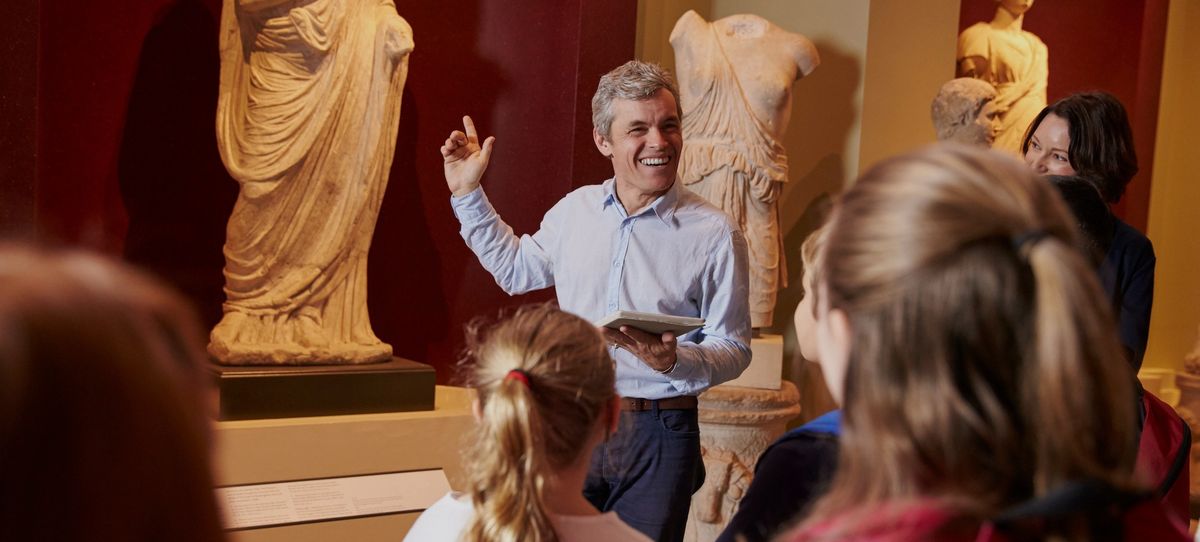 Managing the visitor experience Pupils And Teacher On School Field Trip To Museum With Guide