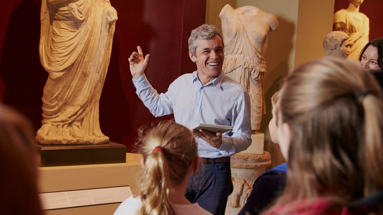 Managing the visitor experience Pupils And Teacher On School Field Trip To Museum With Guide