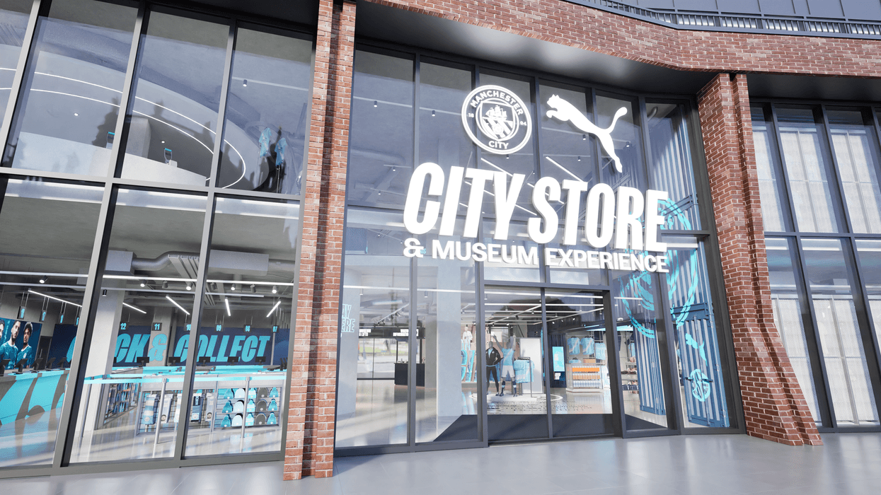 Manchester City store and museum entrance with large windows and brick facade