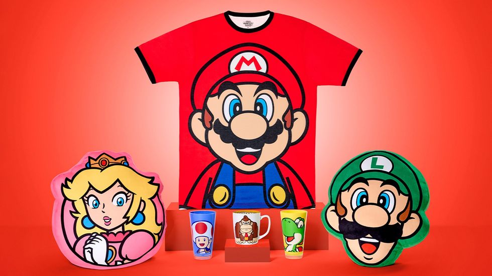 Mario-themed shirt, cushions, and mugs against a red background.